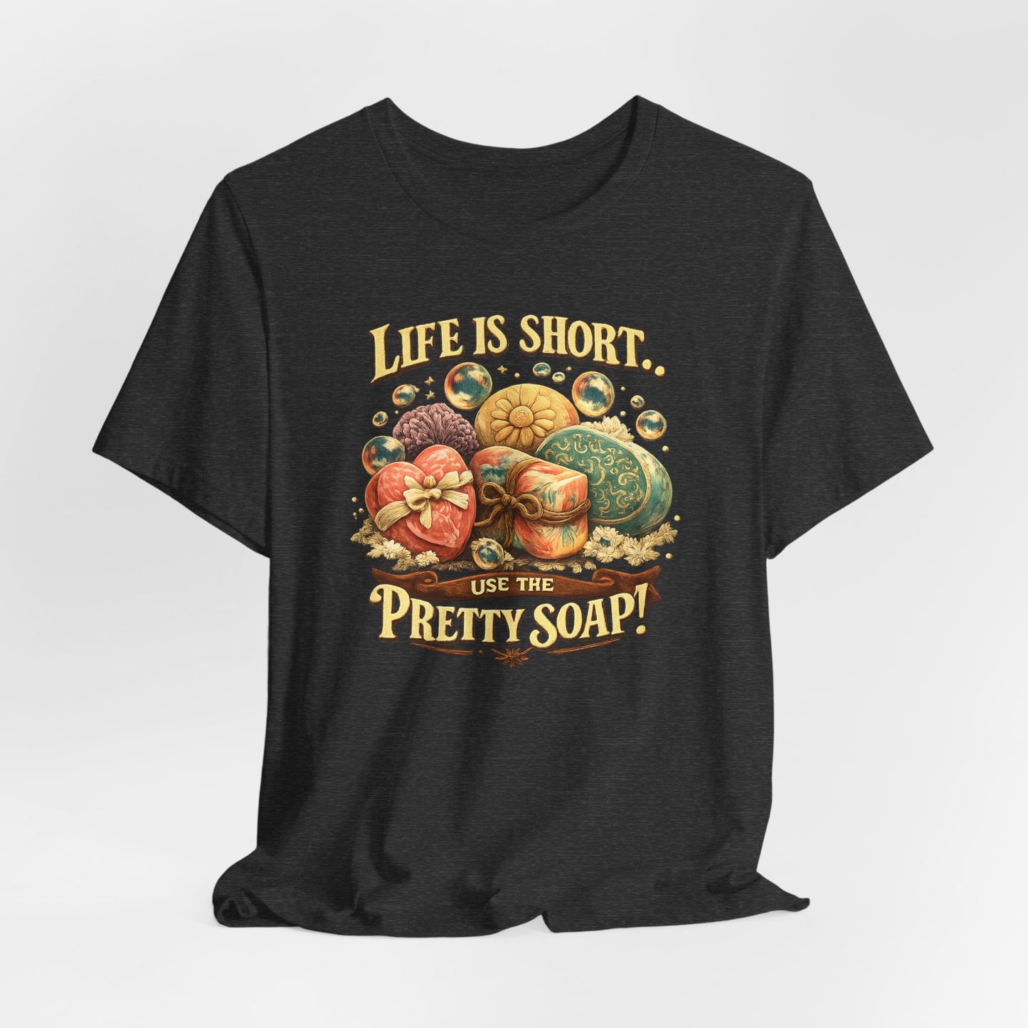 T-shirt displays the playful saying "Life is short, use the pretty soap!" alongside an illustration of beautifully decorated soaps.
