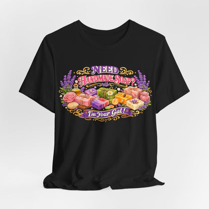Black T-shirt displays a colorful graphic advertising handmade soaps with lavender and rose accents.
