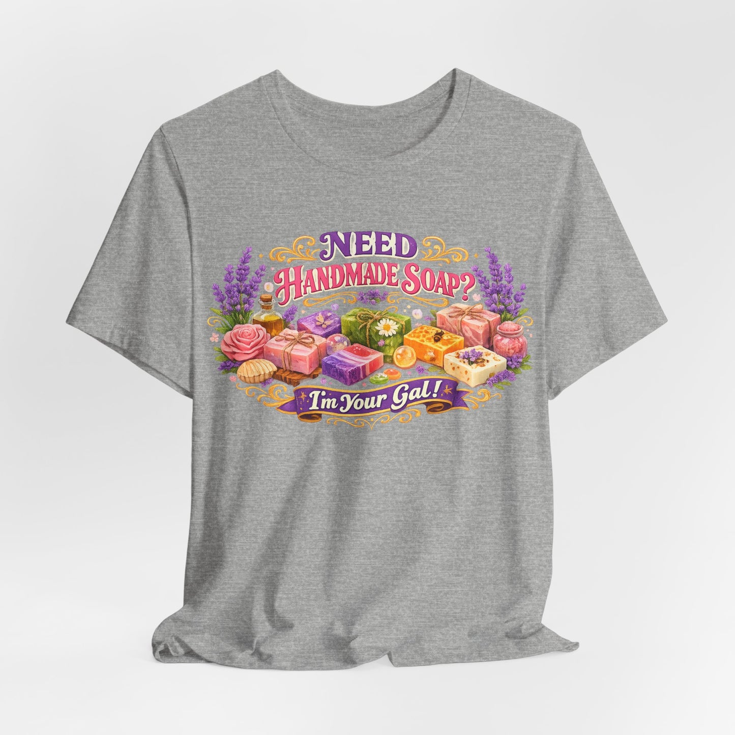 Gray t-shirt displays a colorful "Need Handmade Soap? I'm Your Gal!" design featuring artisanal soaps, lavender, and roses.
