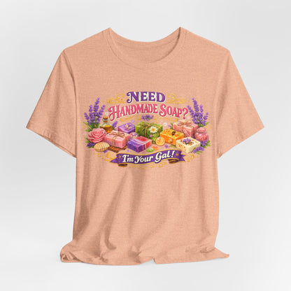 Peach t-shirt displays an illustration promoting handmade soap and a vendor.
